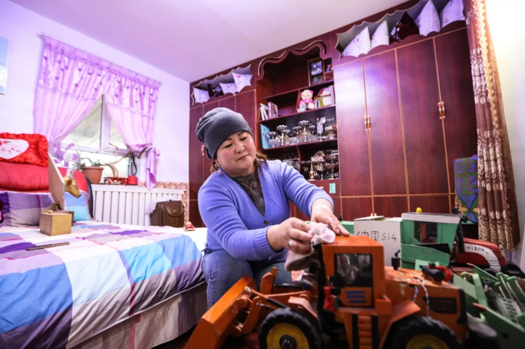 加依娜古丽正在擦拭艾德别克给儿子做的玩具(资料图)